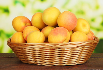 Fresh natural apricot in wicker basket on wooden table