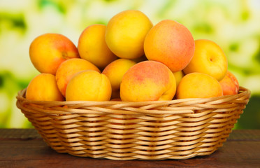 Naklejka na ściany i meble Fresh natural apricot in wicker basket on wooden table