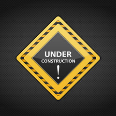 Under conctruction sign on dark metal background