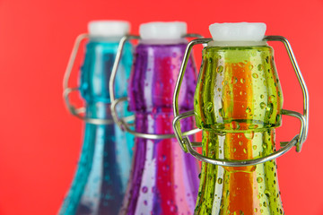 Colorful bottles on red background