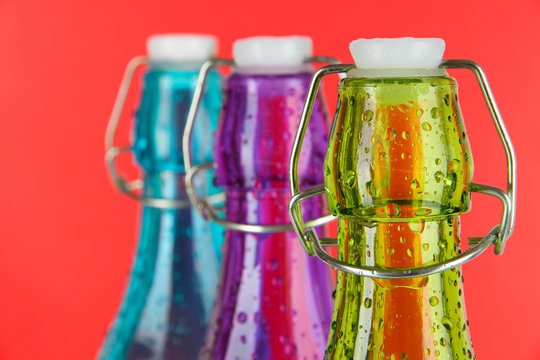 Colorful bottles on red background - Powered by Adobe