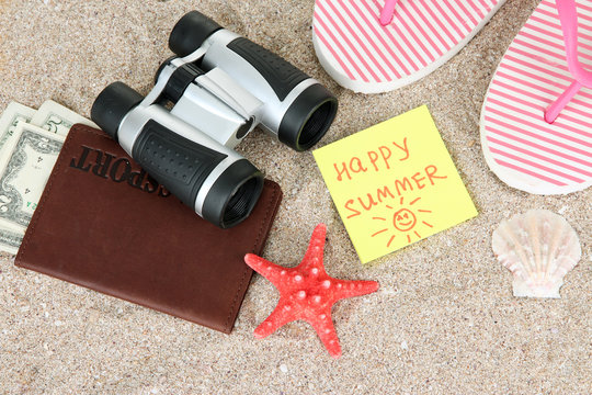 Composition with flip flops, binoculars, notepad and money,