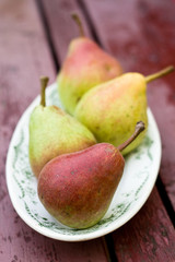 Tasty fragrant pear lying on a white plate