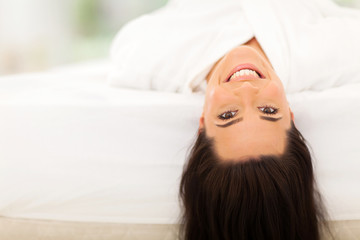 Fototapeta premium happy young woman lying on bed