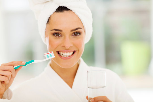 young woman with a smile brushing teeth