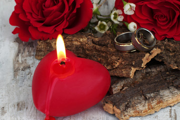 Brennende Kerze mit Trauringen