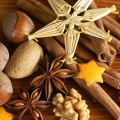Close-up of spices, nuts and Christmas straw decoration