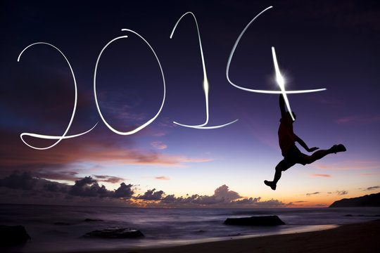 happy new year 2014.young man jumping and drawing 2014 by flashl