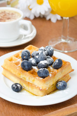 Belgian waffles with blueberries, coffee and orange juice