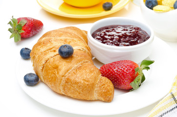 Breakfast with croissant, jam, fresh berries