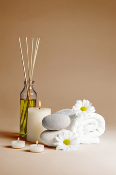 spa decoration with flowers, stones, candles and massage oil