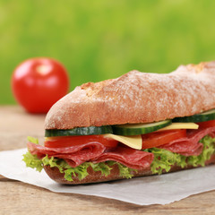 Baguette mit Salami dekoriert mit einer Tomate