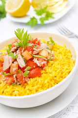 saffron rice with tuna, tomatoes, peppers and greens close-up