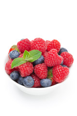 white bowl with fresh juicy berries and mint isolated