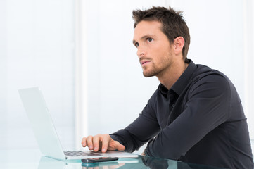 Pensive Businessman Working On Laptop