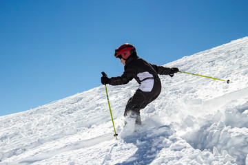 Little boy skier in the deep snow