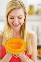 Portrait of happy young woman holding melon