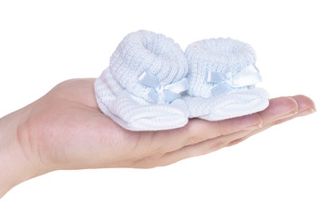Hand hält Babyschuhe