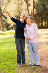 loving middle aged daughter taking senior mother for a walk