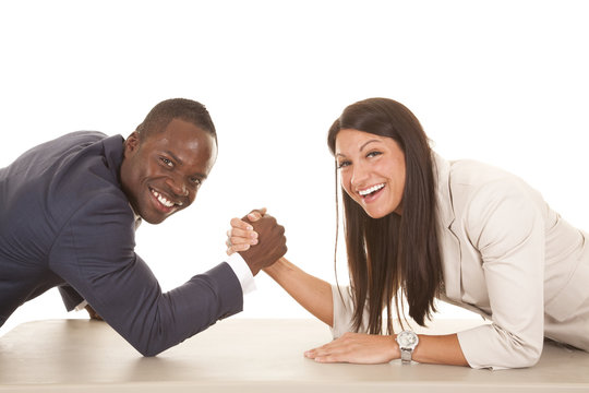 business man and woman arm wrestle laugh looking