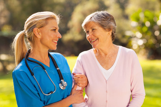 Nurse Talking To Senior Woman Outdoors