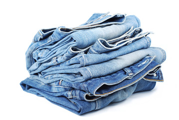 Stack of blue jeans on white background