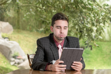Fototapeta premium stressed businessman using his tablet in the house
