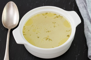 chicken broth in bowl on dark background