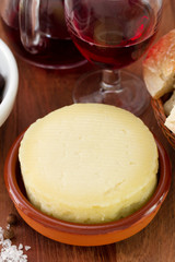 cheese in ceramic dish and red wine