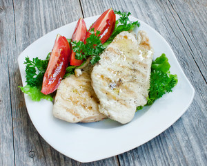 Grilled chicken breast on white plate