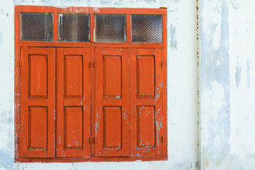 Red wooden window with white wall