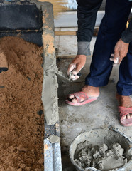 Obraz premium construction mason worker bricklayer making a brickwork with tro