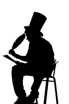 silhouette man sitting on a stool while writing