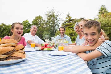 Extended family having dinner outdoors at picnic table