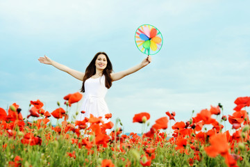 happy girl with windmill in field