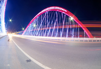 Fototapeta na wymiar cars light trails on the modern bridge at dusk