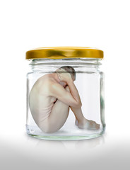 A naked man trapped in a glass jar  with the closed gold color lid