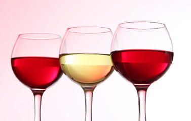 Glasses of wine on light pink tone