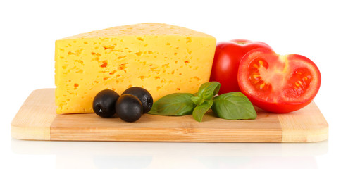 Cheese, basil and vegetables on cutting board isolated on white