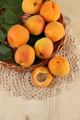 Apricots on wicker coasters on napkin on  wooden table