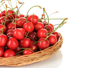 Cherry berries in wicker basket isolated on white