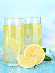 Delicious lemonade on table on blue background