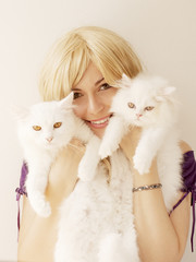 Girl holding two Persian cats