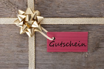 Fototapeta na wymiar golden bow with red tag with Gutschein