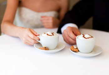 lovers holding cups of cofee in cafe