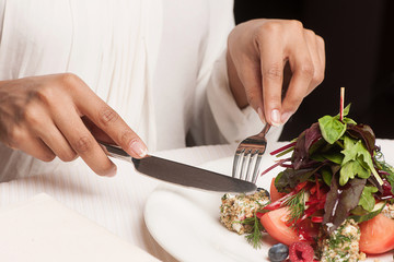 Woman at the restaurant. Cropped image of woman eating at the re