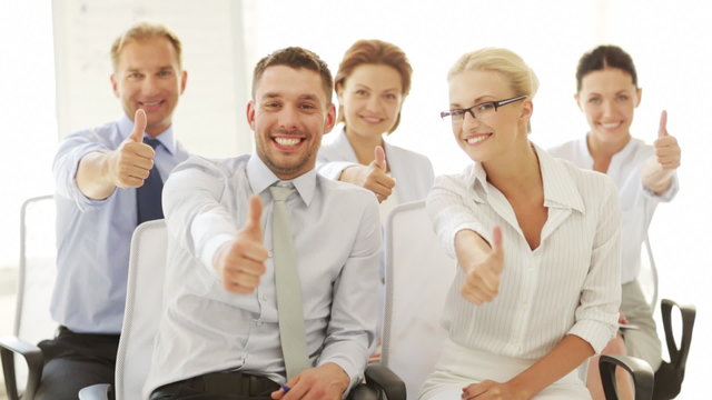 business people showing thumbs up