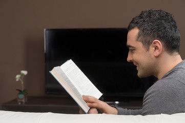 Man reading a book. Side view of cheerful middle-aged man readin