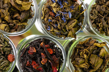 Fototapety  Kolekcja zielonej i czarnej suchej herbaty w talerzach na zielono