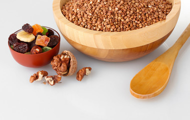 Raw buckwheat with dried fruits isolated on white